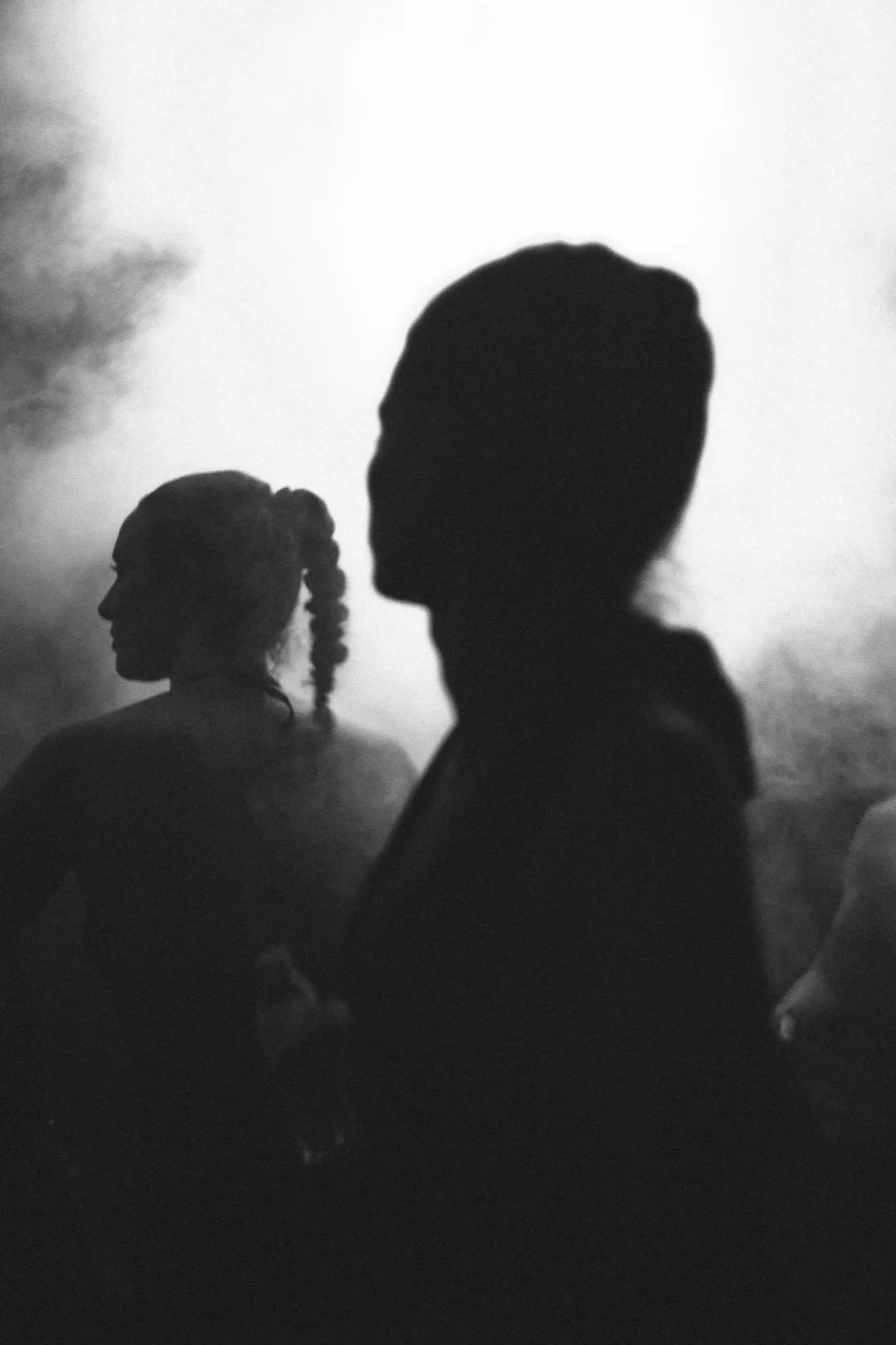 Siluetas en blanco y negro entre el humo de la pista