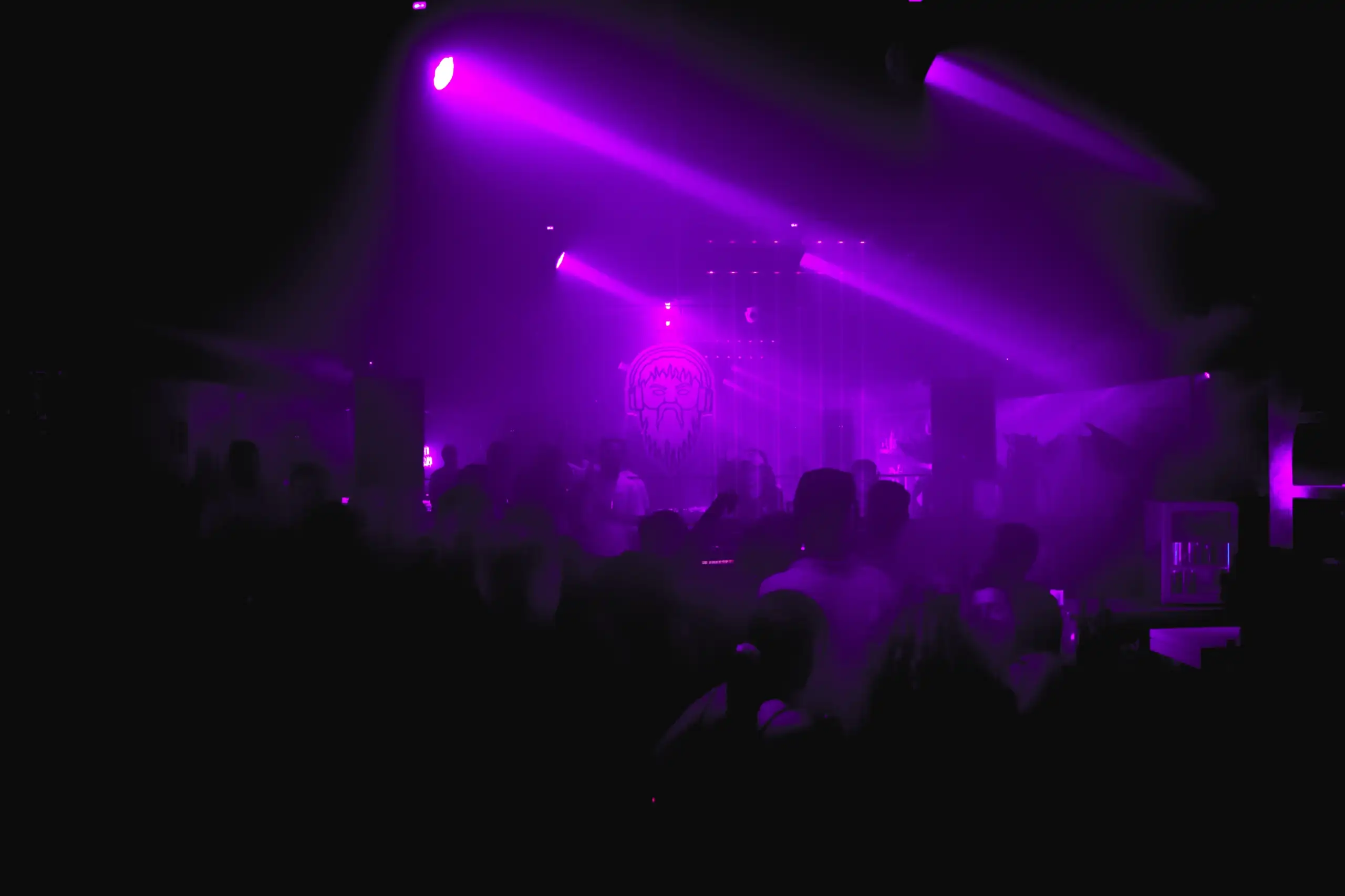 Haces de luz violeta sobre el público de un club