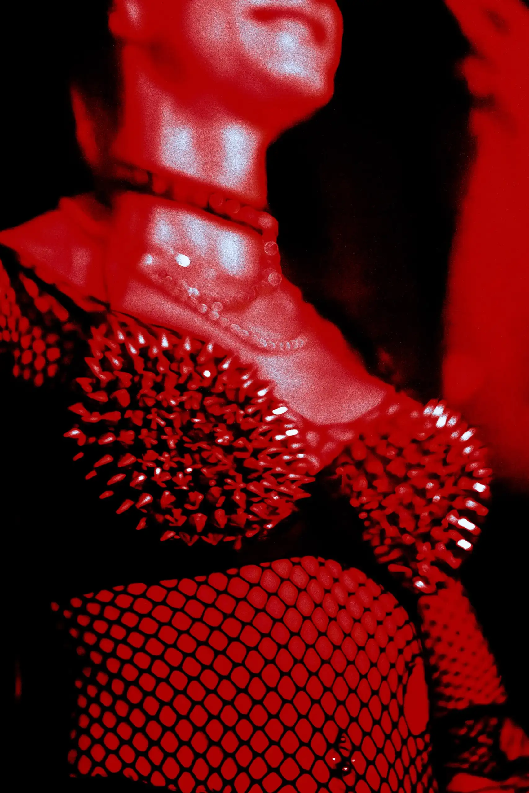 Top de pinchos y camiseta de rejilla bajo luz roja