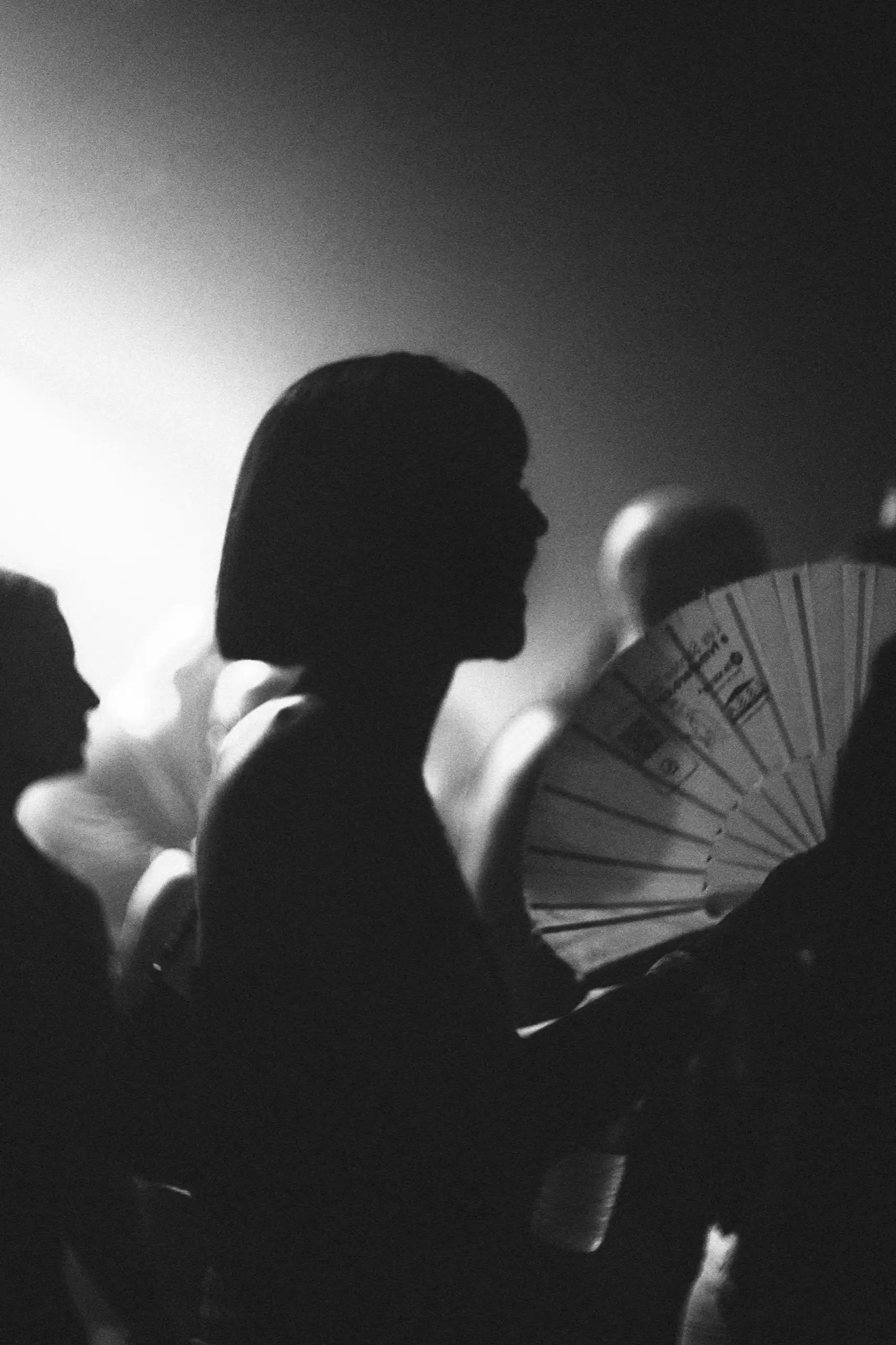 Retrato en blanco y negro de una chica con abanico, a contraluz